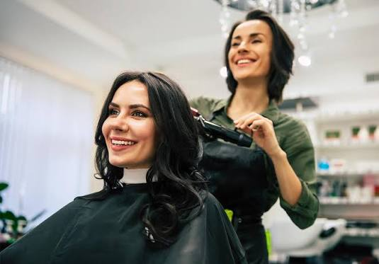 Cabeleireira atendendo uma cliente em um salão de beleza